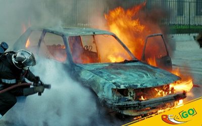 Пожежники тушать палаючий автомобіль.