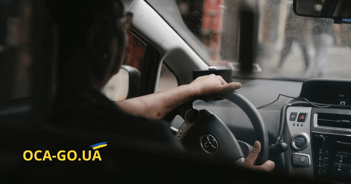 Водій в середині автомобіля тримається за кермо