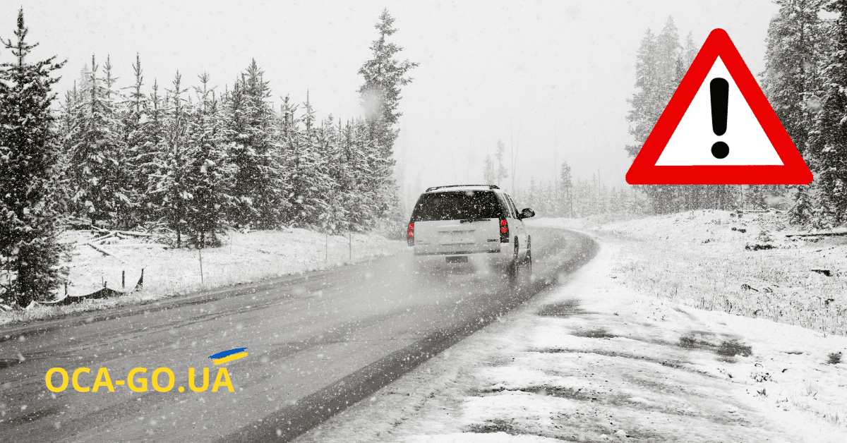 Білий автомобіль на засніженній дорозі за містом серед лісу